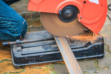 Öğütücüyle metal kesen bir işçi