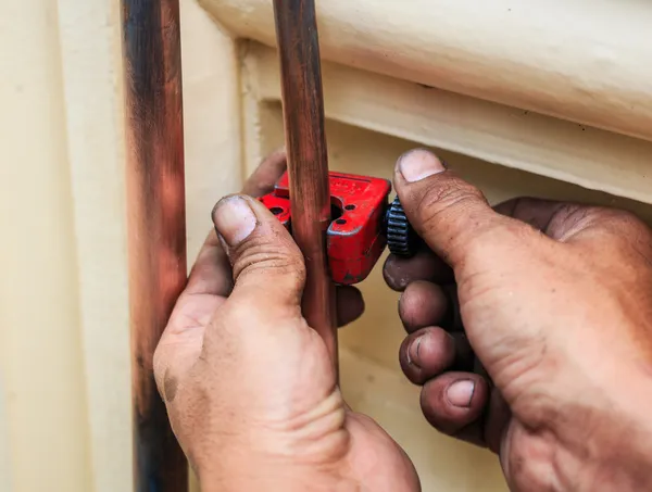 Repairman cut the copper pipe — Stock Photo, Image