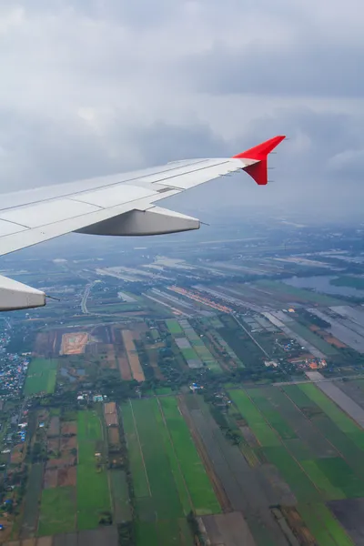 Flygplansvingen ut genom fönstret — Stockfoto