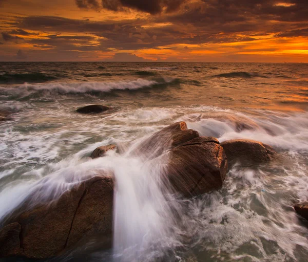 Ηλιοβασίλεμα πέρα από τους βράχους στη θάλασσα — Φωτογραφία Αρχείου