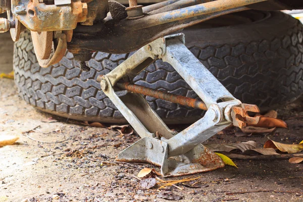 Levantando um carro com jack-screw — Fotografia de Stock