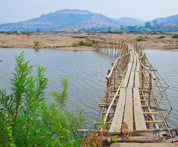 Ponte de bambu através do rio — Fotografia de Stock