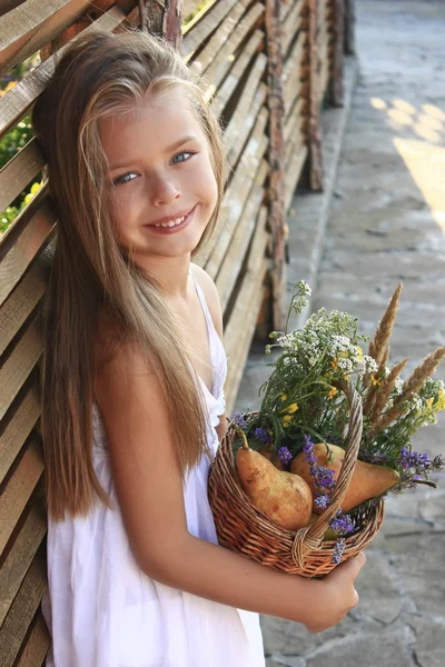 Menina em um vestido branco com flores silvestres — Fotografia de Stock