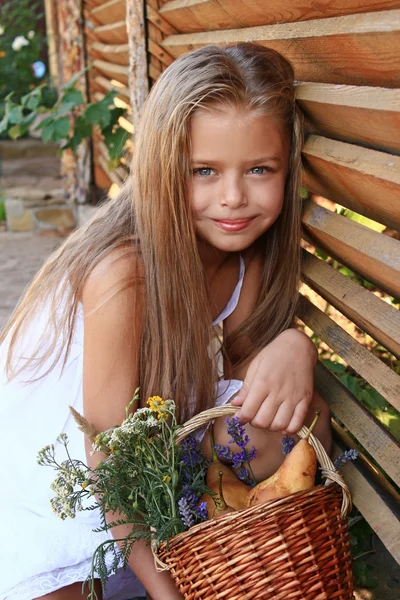 Flicka i en vit klänning med blommor — Stockfoto