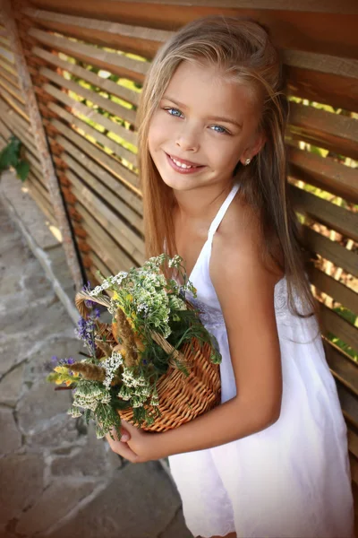 Menina em um vestido branco com flores silvestres — Fotografia de Stock