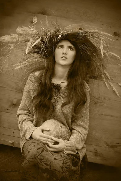 Chica en una corona de otoño con calabaza —  Fotos de Stock