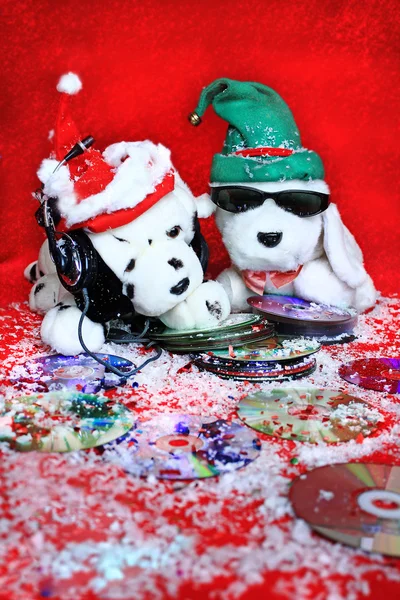 Twee speelgoed honden luisteren naar muziek op een rode achtergrond — Stockfoto