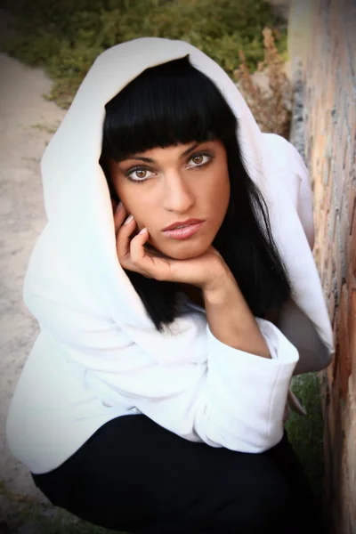 Menina com cabelo preto em um casaco branco — Fotografia de Stock