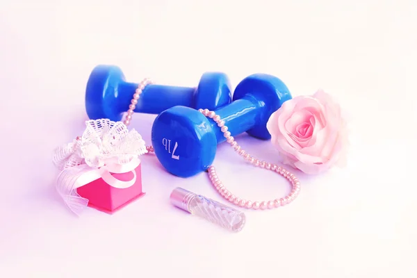 Hantel mit einer Rose und einer Perlenkette auf rosa Hintergrund — Stockfoto