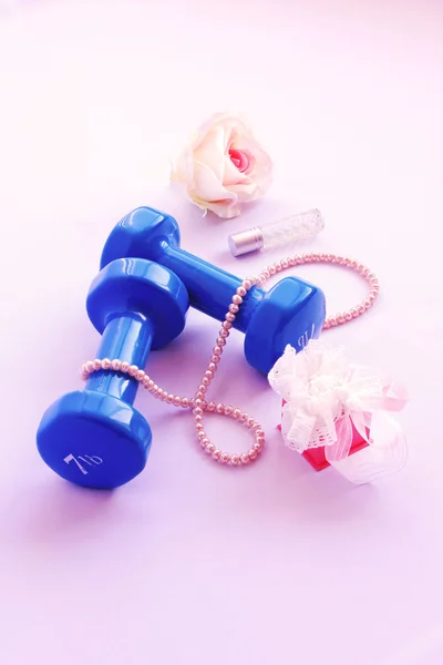 Dumbbell with a rose and a necklace of pearls on a pink background — Stock Image Dumbbell with a rose and a necklace of pearls on a pink background Stock Photo