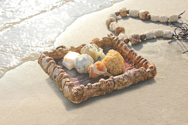 Tray of shells with soap and hand on the beach — Stock Photo, Image