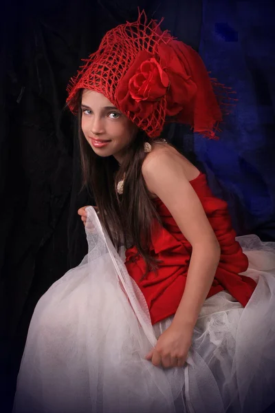 Dívka v červeném klobouku s růží na tmavém pozadí — Stock fotografie