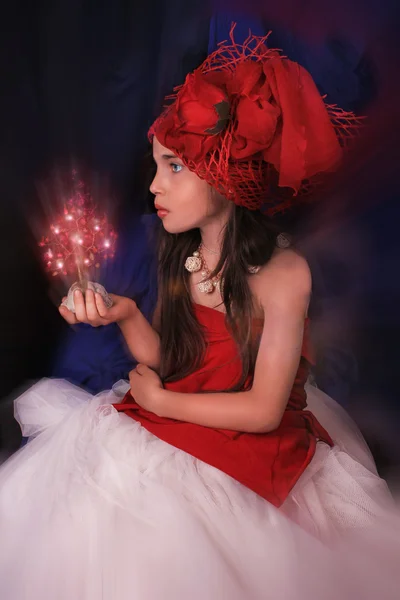 Chica en un sombrero rojo con una rosa sobre un fondo oscuro — Foto de Stock