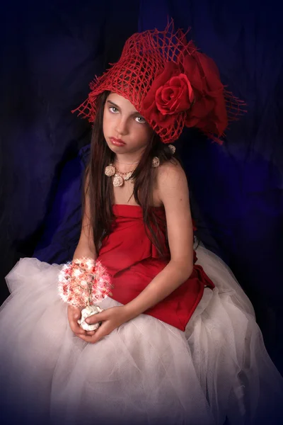 Ragazza con un cappello rosso con una rosa su uno sfondo scuro — Foto Stock