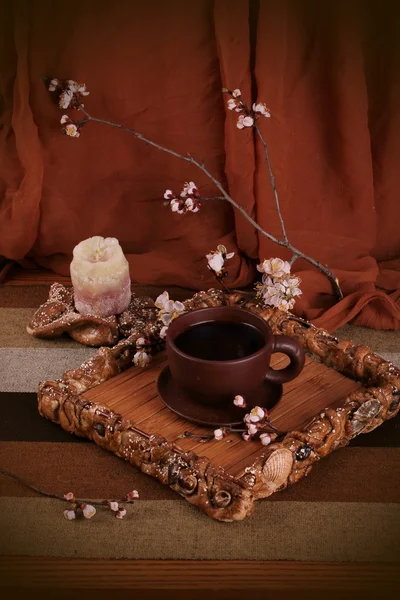 A cup of tea out of clay with blooming cherry twig — Stock Photo, Image