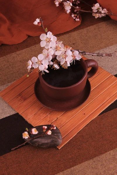 Una taza de té de arcilla con ramita de cerezo en flor —  Fotos de Stock