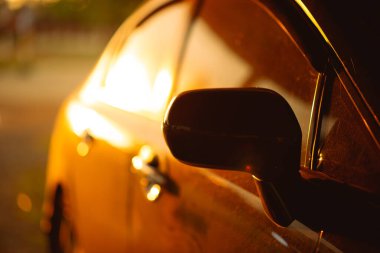 Güneş ışınlarıyla aydınlatılan arabalar gün batımında sarı-turuncu ışık