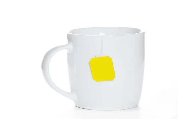 Teabag in cup with yellow label — Stock Photo, Image
