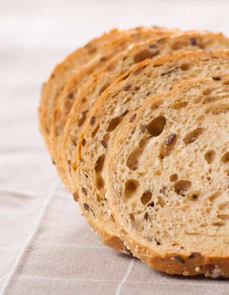 Hälsosamma fullkorn skivat bröd med solrosfrön på brun n — Stockfoto