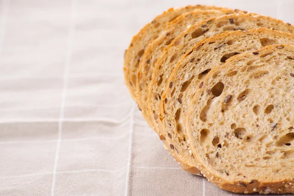 Healthy whole grain sliced bread with sunflower seeds on brown n — Stock Photo, Image