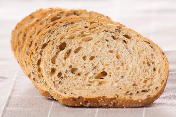 Hälsosamma fullkorn skivat bröd med solrosfrön på brun n — Stockfoto