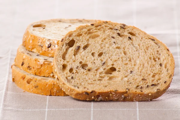 Healthy whole grain sliced bread with sunflower seeds on brown n — Stock Photo, Image