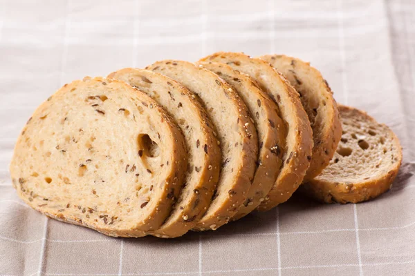 Healthy whole grain sliced bread with sunflower seeds on brown n — Stock Photo, Image