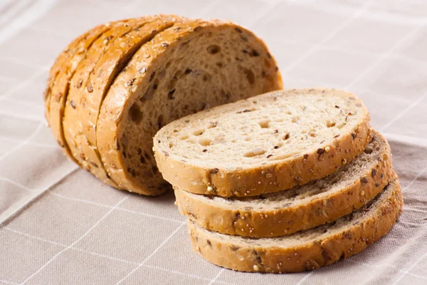 Healthy whole grain sliced bread with sunflower seeds on brown n — Stock Photo, Image