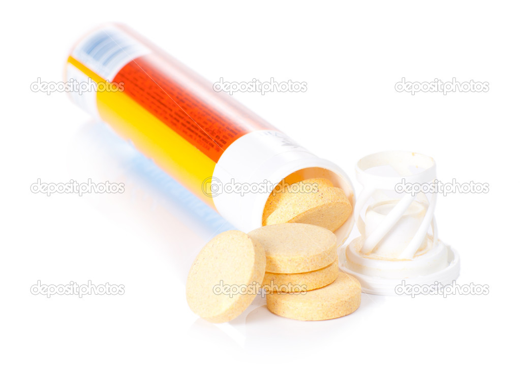 yellow vitamin pills in vial isolated
