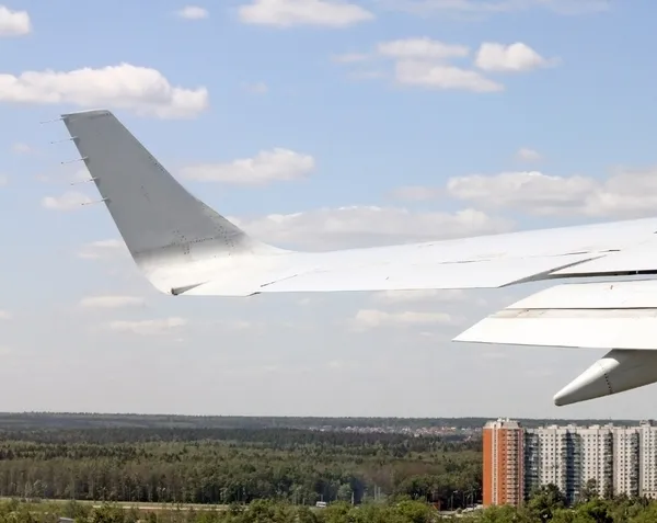 View from airplane of the wing and a city beneath — Stock Photo, Image