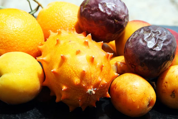 Exotic fruits: orange, kiwano, loquat, peach and passionfruit — Stock Photo, Image