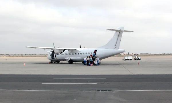 Un avión y pasajeros en la pista listos para embarcar —  Fotos de Stock