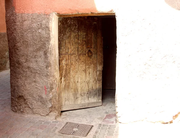 Open old door in the narrow street leading into a dark entrance
