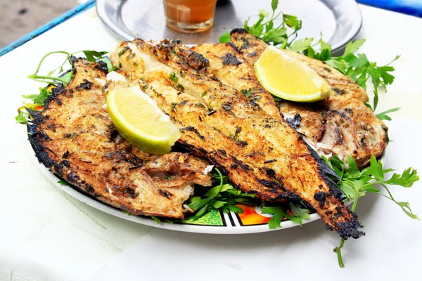 Grilled fish with greens on the plate — Stock Photo, Image