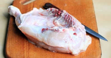 Bıçaklı kesme tahtası üzerinde tavuk budu