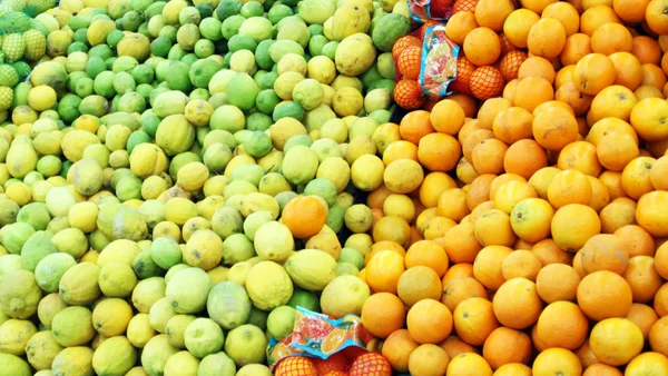 Oranges and green lemons in boxes at the shop — Stock Photo, Image