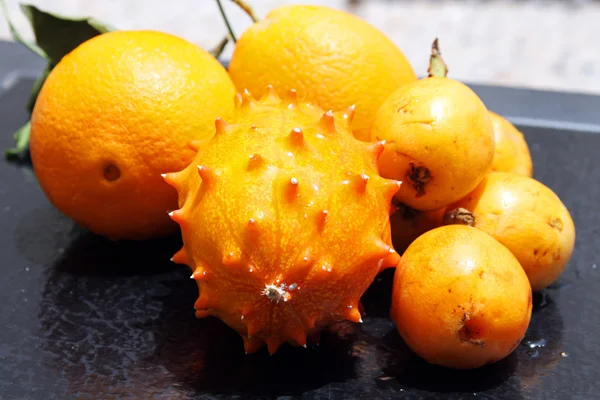 Εξωτικά φρούτα: πορτοκάλι, kiwano και loquat Εικόνα Αρχείου