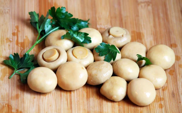 Whole champignons with parsley on the chopping board — Stock Photo, Image