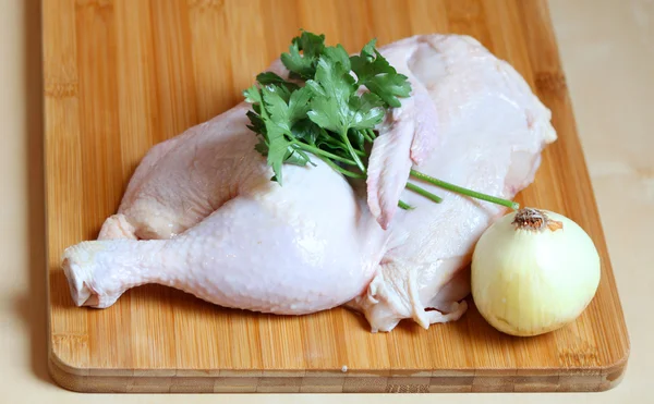 Κοτόπουλο κρέας: το ήμισυ του ολόκληρο κοτόπουλο με μαϊντανό και κρεμμύδι Εικόνα Αρχείου