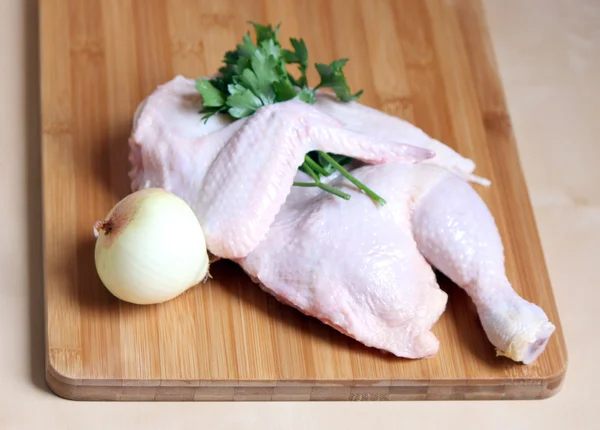 Куриное мясо: половина курицы с петрушкой и луком — стоковое фото