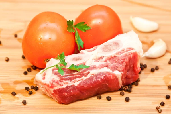 Raw beef with spices and vegetables on the cutting board — Stock Photo, Image