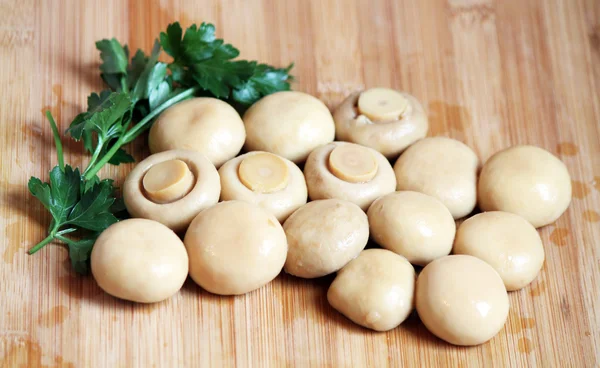 Whole champignons with parsley on the chopping board — Stock Photo, Image