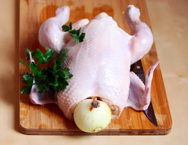 The whole chicken with parsley, onion and a knife — Stock Photo, Image