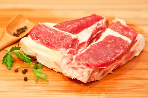 Raw beef with spices and vegetables on the cutting board — Stock Photo, Image