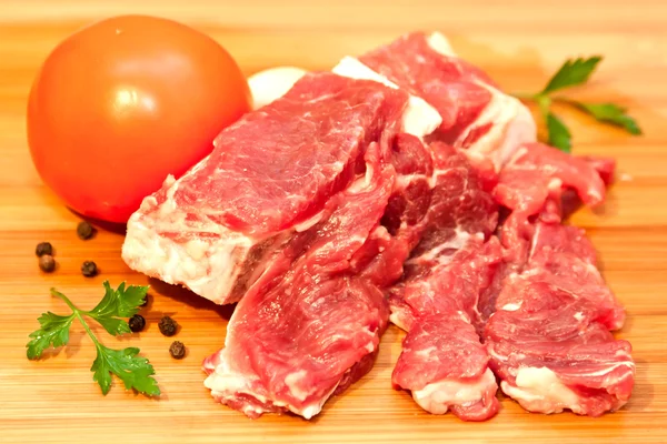 Raw beef with spices and vegetables on the cutting board — Stock Photo, Image