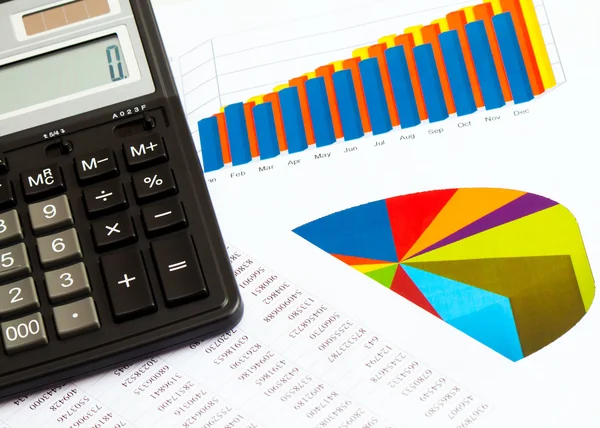 Business picture: calculator and financial graphs — Stock Photo, Image