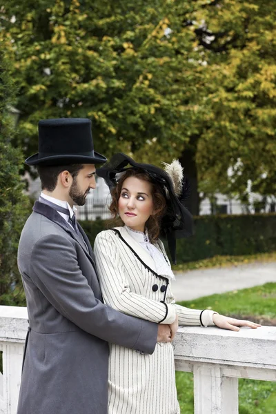 Old-fashioned dressed couple in the park — Stock Photo, Image