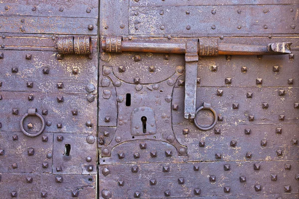 Старая и ржавая дверь со множеством замочек — стоковое фото