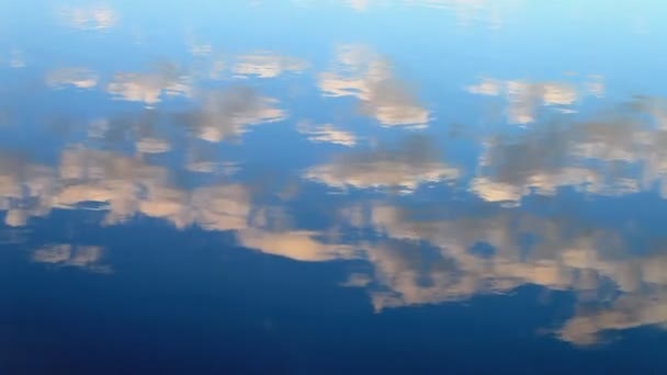 Nuvoloso che si riflette su una superficie d'acqua blu — Video Stock