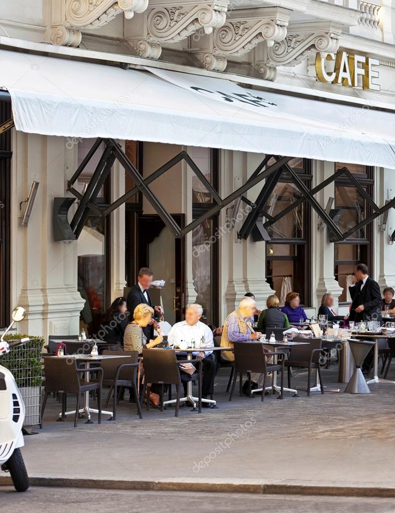 Some people enjoy a cup of coffee at a traditional Viennese Cafe
